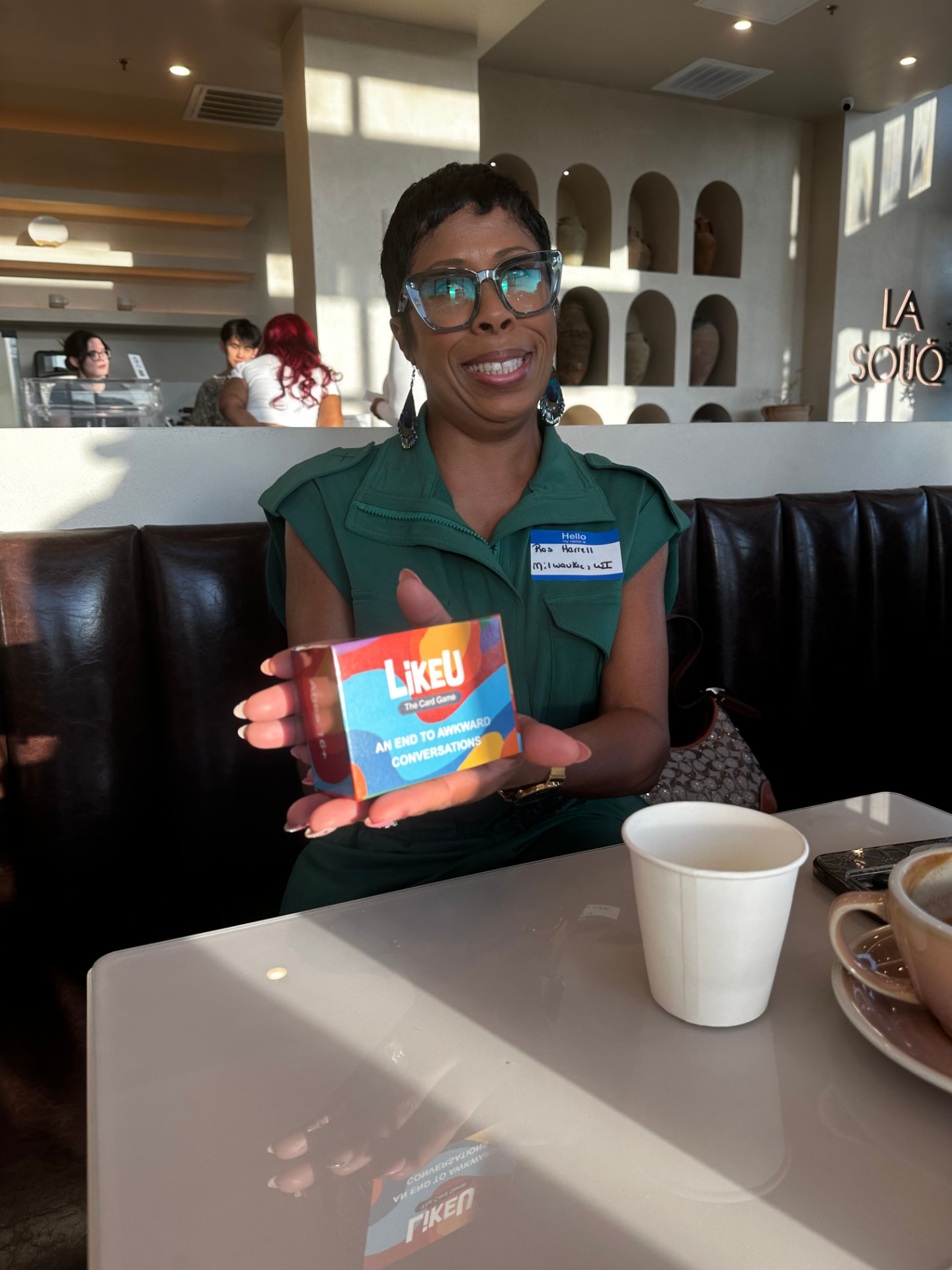 Smiling guest holding a conversation card game at a gathering