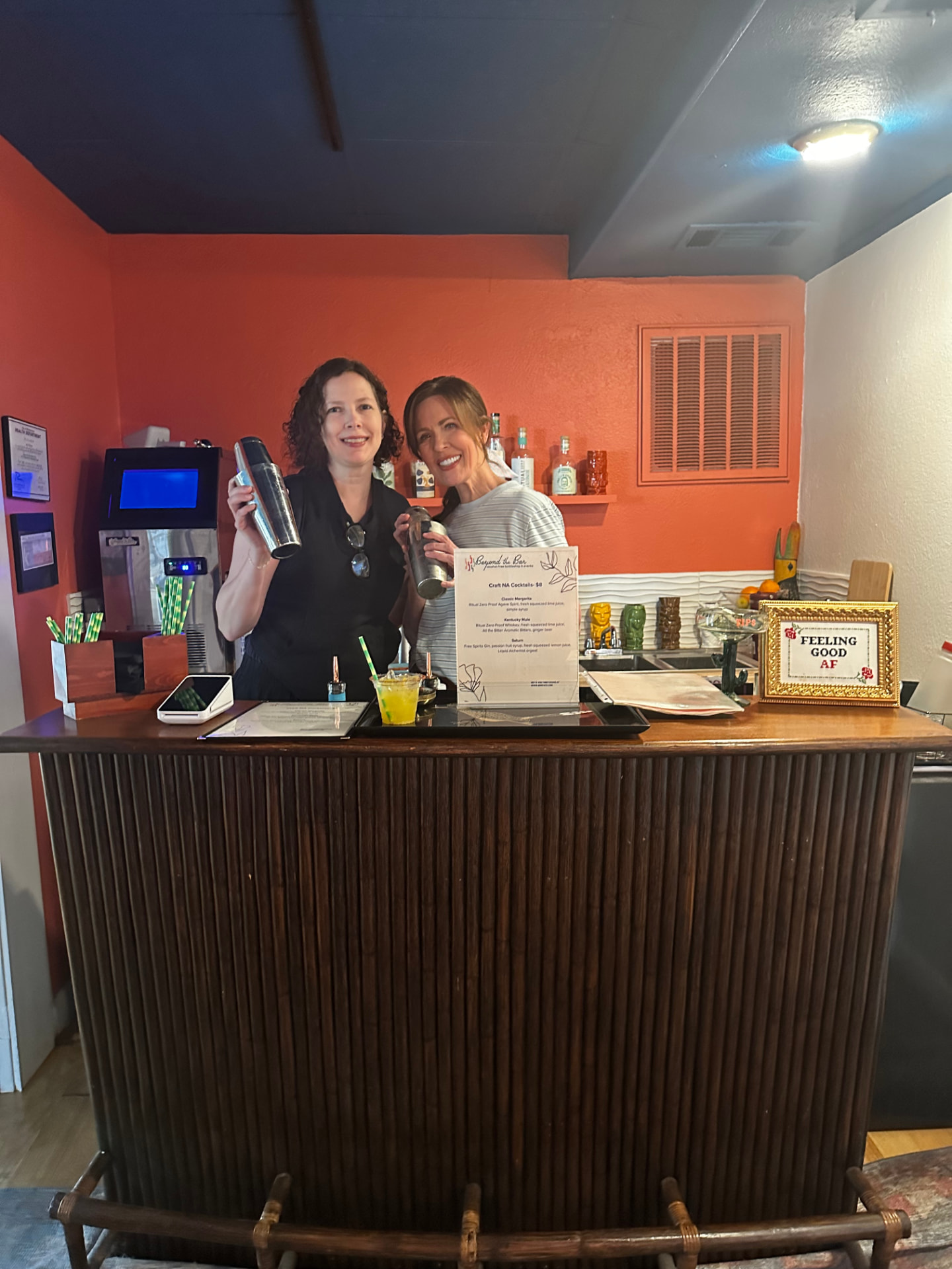 Two hosts mixing drinks behind the bar at an NFHE event