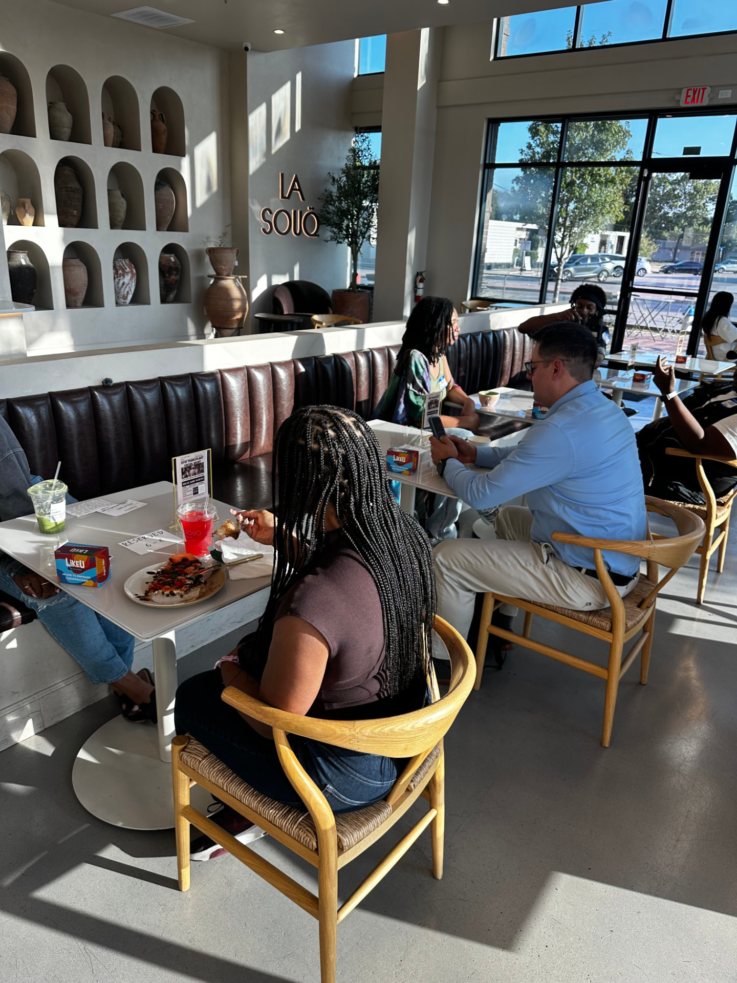 Guests enjoying food and conversation at a sunlit cafe gathering