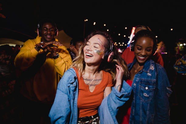 Guests dancing outdoors at night with headphones